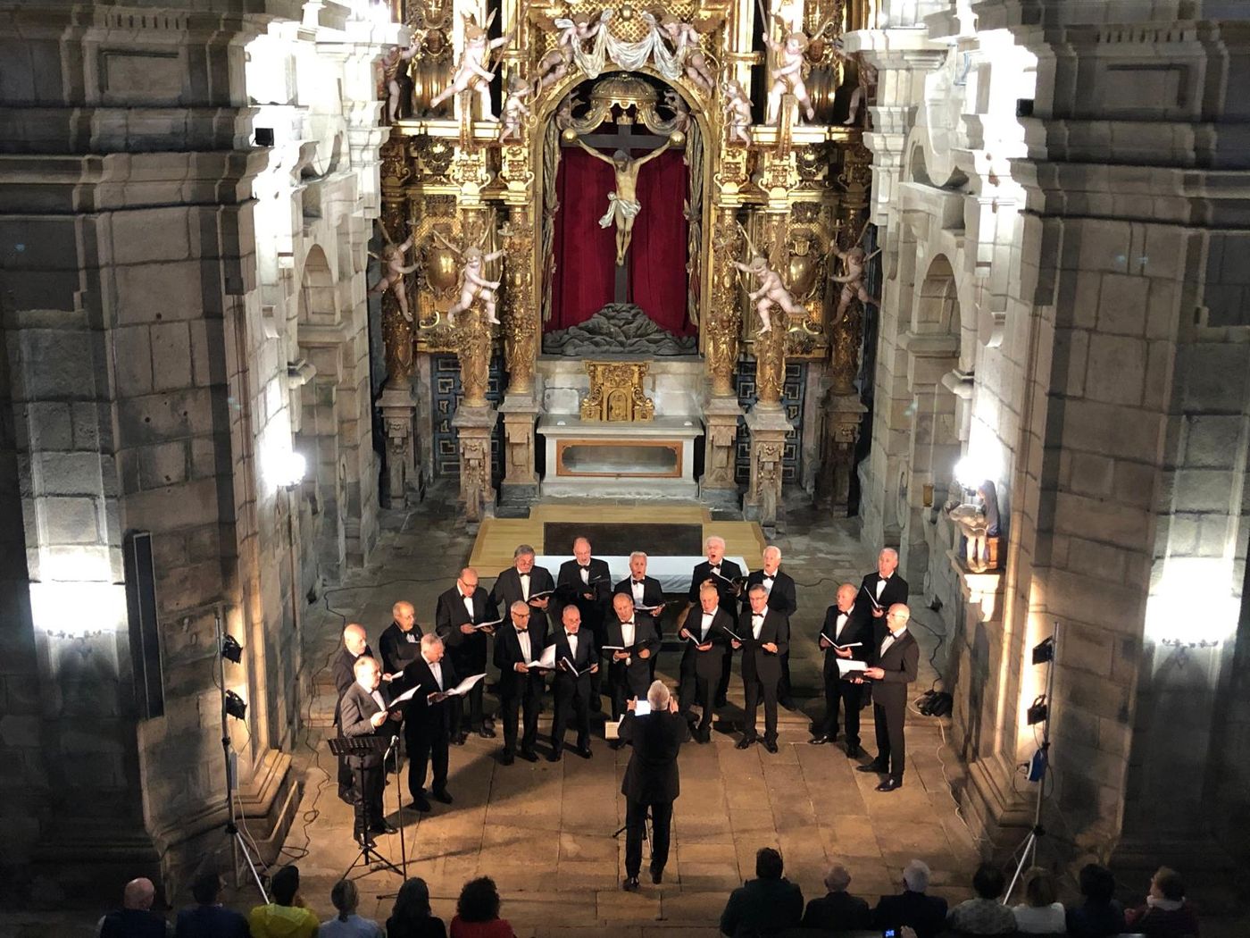 O coro cantando nunha igrexa barroca chea de público, visto desde o coro alto