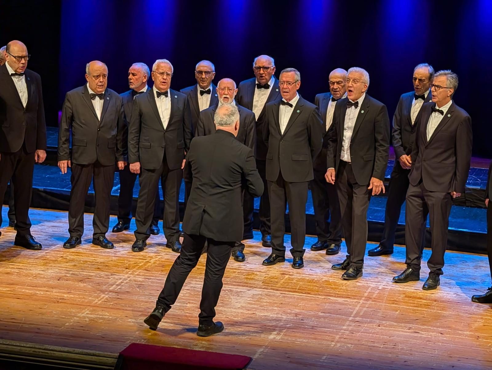 O Coro Crecente en escena, co seu director de costas diante dos coralistas